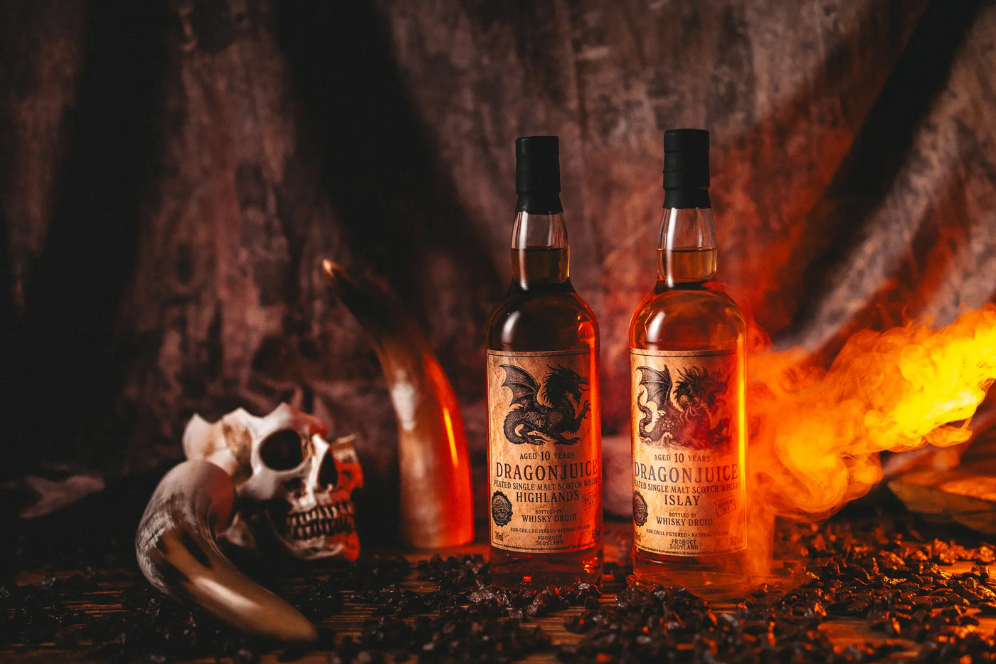 Dragonjuice Islay 10 Jahre & Dragonjuice Highlands Peated 10 Jahre – Batch 1 in rauer Umgebung vor Feuer und neben Knochen und Schädel