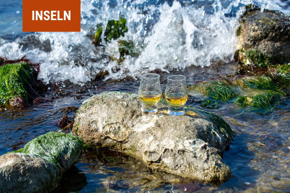 Zwei Gläser Whisky auf einem Stein an der schottischen Küste