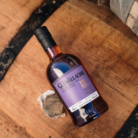 GlenAllachie 12 Jahre Single Malt Whisky Flasche liegend auf einem Holzfass