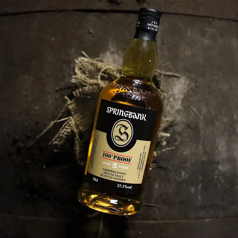 Springbank 100 Proof 5 Jahre Single Malt Whisky liegt auf einem Holzfass