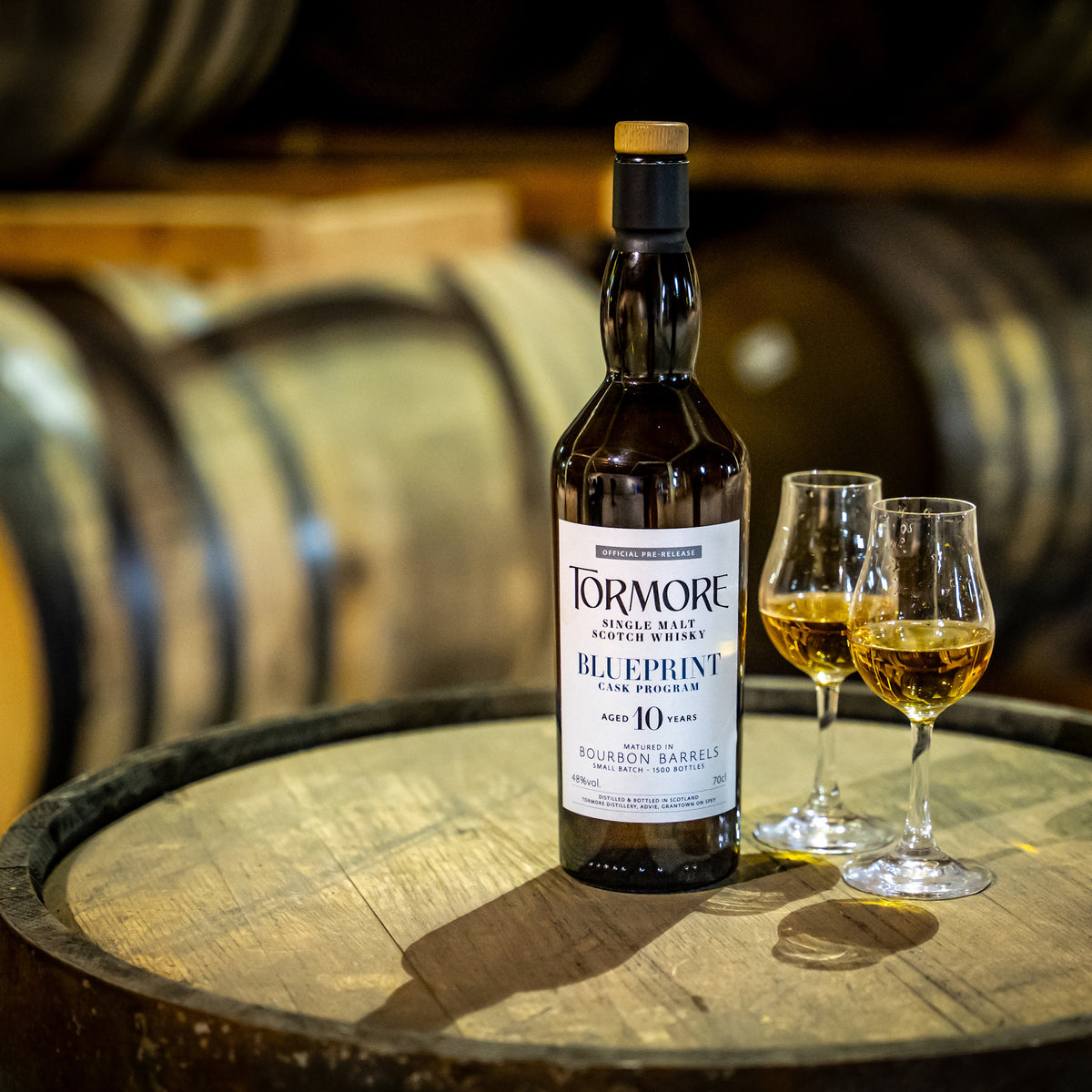 Tormore Single Malt Whisky Flasche und zwei gefüllte Gläser auf Holzfass in Whisky-Destillerie