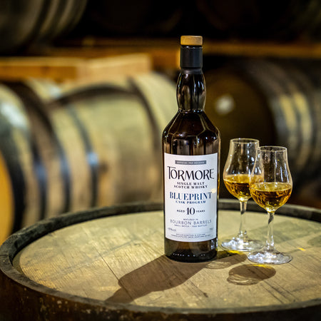 Tormore Single Malt Whisky Flasche und zwei gefüllte Gläser auf Holzfass in Whisky-Destillerie