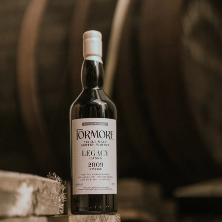 Tormore Legacy Casks 15 Jahre 2009/2025 Whisky vor einem Holzfass